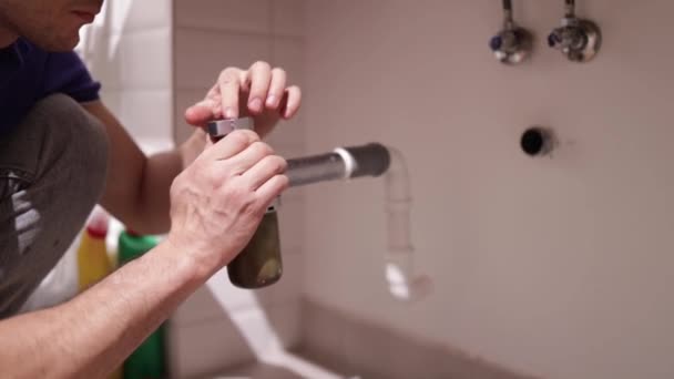 배관공 욕실에서 싱크대에 배관공은 시스템의 누출을 수정하고 시폰을 수집합니다 — 비디오
