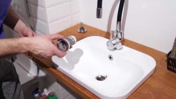 배관공 욕실에서 싱크대에 배관공은 시스템의 누출을 수정하고 시폰을 수집합니다 — 비디오