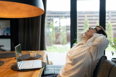 Boyun ağrısından muzdarip yaşlı, olgun bir iş kadını masada oturmaktan yoruldu. Kadın uyukluyor, başını arkaya yaslamış dinleniyor..