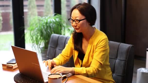 Fiatal Ázsiai Szemüvegben Laptoppal Kommunikál Interneten Ügyféllel Otthon Újrahasznosítható Kávé — Stock videók
