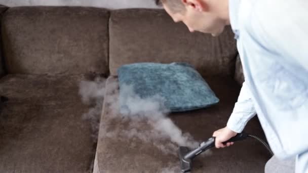 Sprzątanie Domu Mężczyzna Czyści Sofę Meble Generatorem Pary Sprzątanie Mieszkania — Wideo stockowe