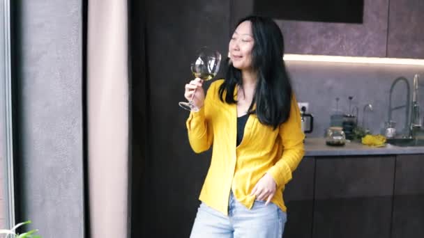 Aziatische Vrouw Holding Wijnglas Kijken Door Venster Keuken Thuis — Stockvideo