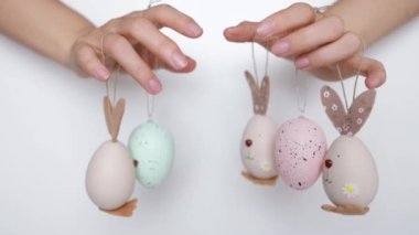 Paskalya yumurtası tutan çocuk elleri. Komik yüzlü ve tavşan kulaklı. Paskalya için hazırlık, el yapımı resim konsepti. Kapat..