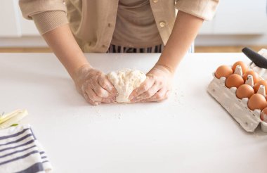 female hands skillfully kneading raw bread dough for homemade bread cooking. Bakery concept. Close-up. Preparation of the dough.