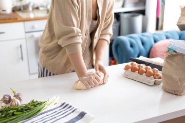 female hands skillfully kneading raw bread dough for homemade bread cooking. Bakery concept. Close-up. Preparation of the dough.