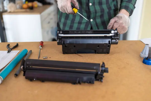 Ink replacements in printer cartridge. Printer service concept. Disassembly of the printer cartridge for its maintenance and refilling with toner.
