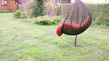 Yaz bahçesinde rahat bir hasır beyaz sandalye. Hafta sonu için rahat bir yer bahçede rahatla. Arka bahçede asılı hamak sandalyesi. Açık havada dinlenme kavramı.