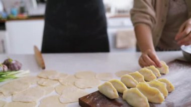 Çift içeride mutfakta hamur tatlısı hazırlıyor.