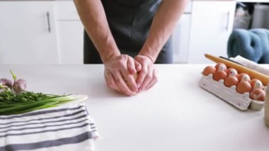 Adamın elleri hamuru yoğurur. Un veya hamur pişirmek için gereken malzemeler (ekmek, kek, pasta, pizza hamuru)). 