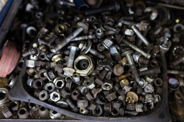 Steampunk dokusu, mekanik parçalı arka plan. Kirli zeminde birçok araç, Set Ustası aracı, mekanik aletler. Otomatik tamir servisinde çalışmak için farklı araçlar kullanan profesyonel bir tamirci.