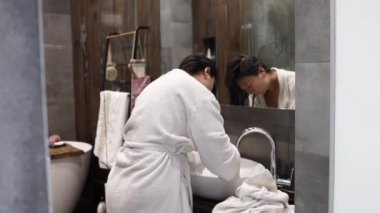 Banyoda duş aldıktan sonra kuruyan Asyalı kadın..