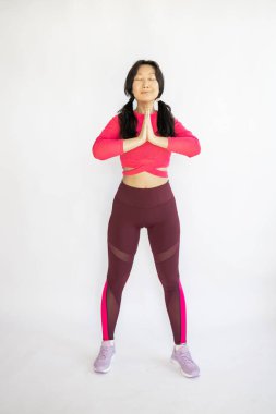 Güzel, gülümseyen, mutlu genç bir kadın, içeride çalışıyor, yoga yapıyor, Vrksasana Duruşu, Ağaç Duruşu, tam boy.