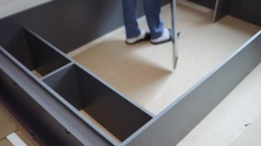 Genç adam gardırop hazırlıyor. Profesyonel Tamirci, Yeni Ev 'e taşınan insanlara yardım ediyor..