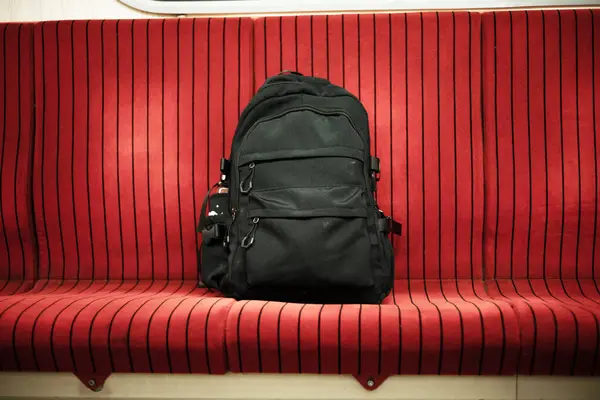 stock image a black bag on the seat in bus. Abandoned, unattended cabin backpack on chair inside subway train.