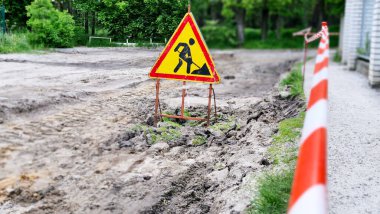 Çalışmalar devam ediyor. Yol çalışması, yol işaretleri. İş yerindeki erkekler. Şehir caddesinde devam eden işler için bazı işaretler var. Bariyerler ve yol işaretleri. Mühendislik iletişim yollarının onarılması.