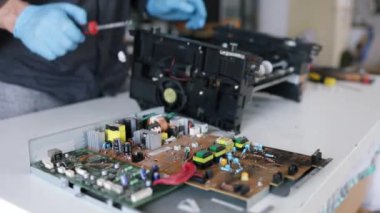 printer repair technician. A male handyman inspects a printer before starting repairs in a client's apartment.