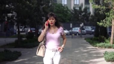 Genç hoşnutsuz bir bayan akıllı telefon görüşmesi yapıyor. Şehirde telefon görüşmesi ya da stres. 