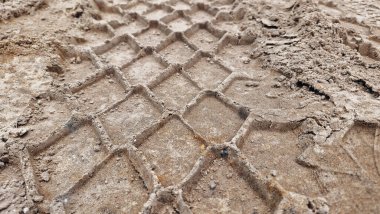 Kumda çekici tekerlek izi var. Toprak bir yolda tekerlek izi.