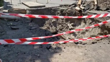 Kırmızı ve beyaz uyarı bandı zemin ile bulanık bir zemin boyunca uzanıyordu. Tehlikeli bir inşaat alanının sınırını belirleyen güvenlik bandı.