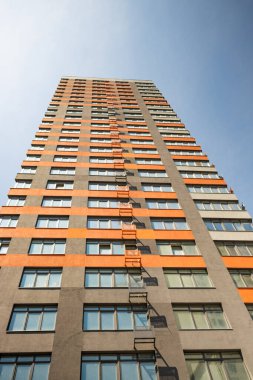 Modern, uzun, çok katlı, mavi gökyüzüne karşı cam cephe oluşturan, yazı için yeri olan bir bina. Konut binaları, ofis binaları, tesisler. İnşaat işi. Emlak yatırımı.