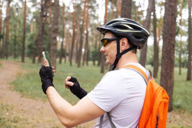 Yoğun egzersizden sonra dinlenen bir sporcu. Dinlenirken Smartphone kullanan bisikletçi. Akıllı Telefon ve Arkadaşlarla Mesaj Kullanan Atletizm Sporcusu Bisiklet Sürdükten ve Sosyal Ağ 'da Sohbet ettikten Sonra Dinleniyor