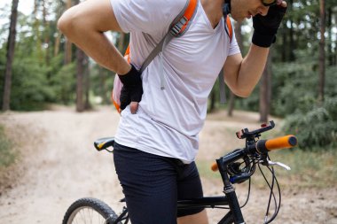 Spor, spor sakatlığı ve bisikletçinin sırt ağrısı dağ yolunda bisiklet sürerken rahatsız oluyor. Antrenman, ağrı ve eklem, kas ve omurilik rahatsızlığı olan yaralı bir atletizm hastası..