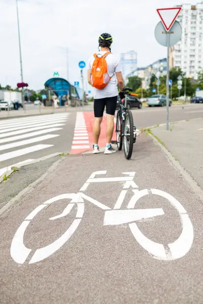 stock image traffic, city transport and people concept - man cycling along bike lane with signs of bicycles on street.