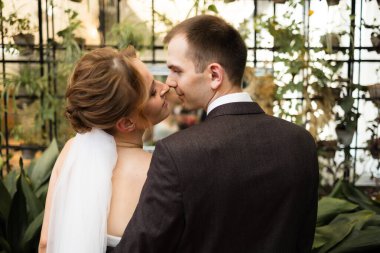 Beyaz, güzel bir gelinlik içinde gelin ve siyah takım elbiseli ve beyaz gömlekli damat oturuyor ve sarılıyorlar. düğün ve aşk. portre fotoğrafı..