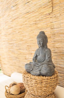 Buda heykeli ahşap duvarın arkasında duruyor.