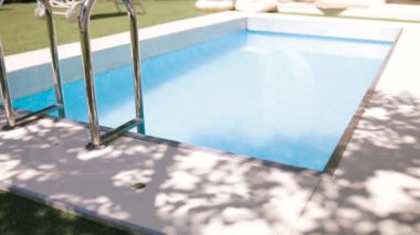 Lüks villada yüzme havuzu ve sandalye. Güneşli yaz gününde teraslı otel havuzunda lüks bir yüzme havuzu..