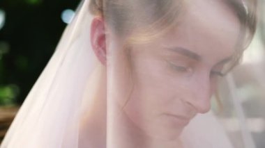 Yüzünde dantel peçeyle mutlu tatlı bir gelinin yakın plan portresi. Uzun peçeli bir gelin. Düğün günü..