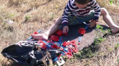 Bir çocuk yere plastik bir araba monte ediyor..