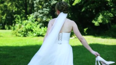 Beyaz gelinliğin kıvrımlı kenarına yakın plan. Gelin bahçede dans ediyor.. 