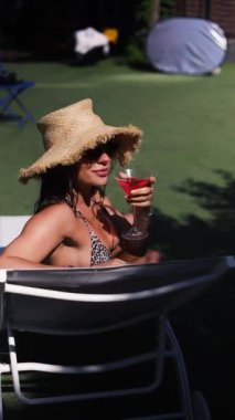 Taze kokteyller hazır. Genç kadın gündüz vakti yüzme havuzunda iyi eğlenceler. Bölge spa otelinde tatil ve dinlenme. Yaz.