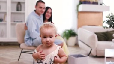 Genç beyaz anne-baba ve yeni doğmuş bebek evde oynuyorlar. Çocuk yetiştirme kavramı.