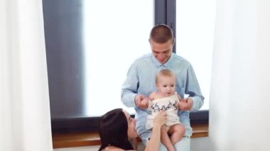 Genç beyaz anne-baba ve yeni doğmuş bebek evde oynuyorlar. Mutlu aile çocuğu hayali konsepti. Mutlu yaşam tarzı aile içi konsept.