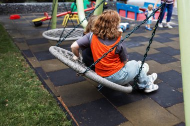 Anne Kaliteli Zamandan Hoşlanıyor Oğluyla salıncakta sallanıyor Güneşli bir günde Modern bir oyun bahçesinde