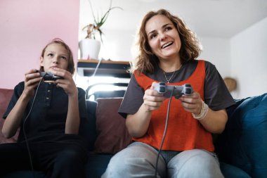 Mother and son playing video games, having fun and enjoying quality time together. Cheerful, bonding and carefree child and parent using a gaming console or interactive modern technology