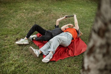 Anne ve oğlu yaz parkında tablet kullanıyorlar.