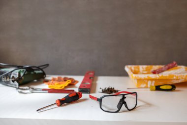 Gri zemin üzerinde bina seviyesi ve diğer inşaat araçları ile bileşim. 