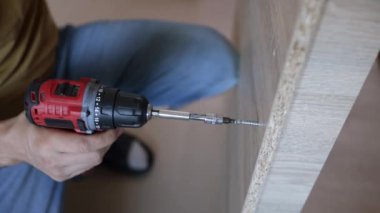 Genç bir zanaatkar mobilya montajı yapıyor. Teyidi yakın plan çekiyoruz. Profesyonel mobilya montajı. Yeni mobilya montajı. Mobilya kurulumu. 