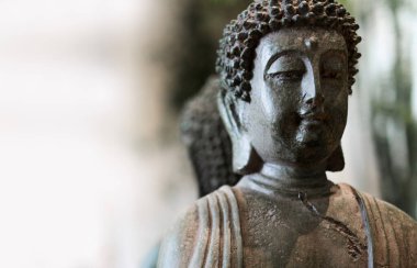 Buda yüzlü heykel, arka planı kapatın. Budizm dinindeki bir taştan yapılmış bir Buda heykeli portresi..