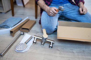 Adam bir tesisatçı, tuvalet lavabosu için yeni vinç açıyor. Mutfak lavabosunun üzerine yeni bir musluk kuruyorum.