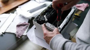 Yazıcı tamircisi yazıcının içini inceliyor. Ofis donanımında profesyonel yazıcı bakım teknik yardımı kavramı. Mürekkep sisteminin sürekli onarımı. Yazıcı sorunları. Dikey video