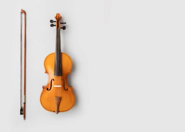 Müzik konsepti için kopyalama alanı olan boş beyaz desenli bir duvar zeminine yaslanan keman