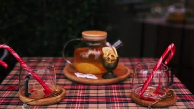 Cam çaydanlıkta sıcak meyve çayı, verandadaki Noel masasında iki fincan, kış şenliği havası..