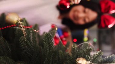 Evdeki kırmızı top süsleriyle güzel Noel ağacını süsleyen kadının dikey videosu..