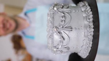 Kafkasyalı mutlu bir pasta şefi pastayı şekerli ve fındıklı gösteriyor..