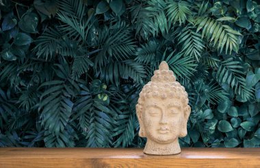 Zen bahçesindeki tropik yapraklı Buda heykeli. Ruhsal uyanış. Buda heykeli ve küçük bir meditasyon. Buda arkaplanının beyaz yüzünü meditasyon yapan Zen ruhani ayini. Din konsepti, ezoterik. 