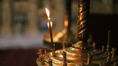 Kilisedeki bir şamdanda küçük bir kilise mumu yanıyor. İnanç ve barış kavramı, keder.